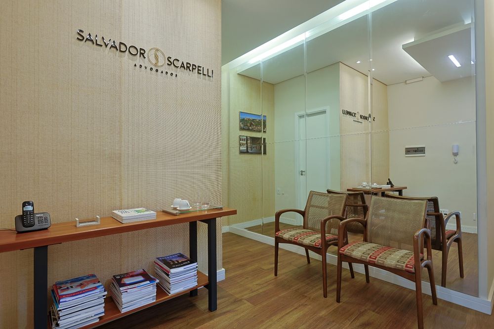 Recepção do escritório Salvador Scarpelli Advogados, com sala de espera e identidade visual na parede