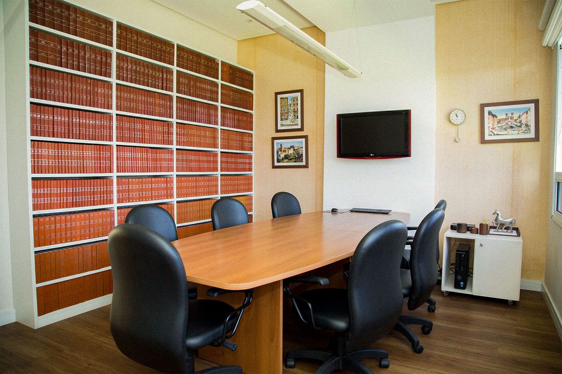 Sala de reunião com biblioteca jurídica do escritório Salvador Scarpelli Advogados